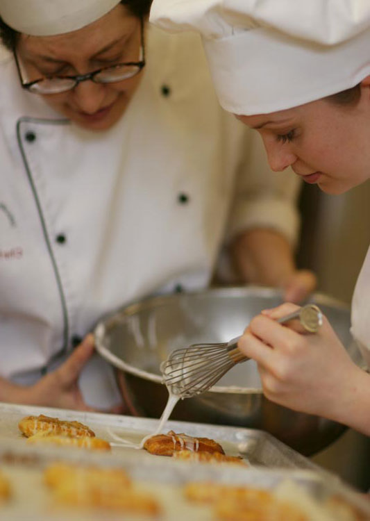 Pastry Chef dripping caramel on croissant